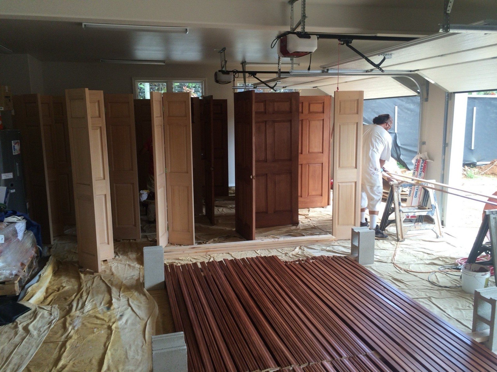 A row of solid wood doors finished in three deepening stain tones, hand-blended across panels to read as a single deeper hardwood, representative of color-matched stain craft