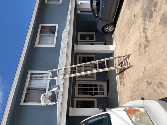 Two-story blue residence completed and ready, work truck staged in the foreground